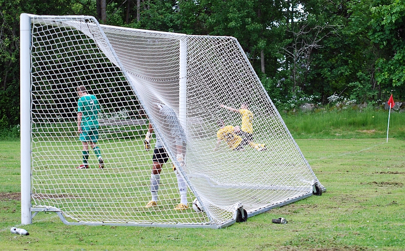 2010_0613_23.JPG - En glad målskytt (delvis skymd av nätet) gör målgest medans målvakten hämtar ut bollen ur målet
