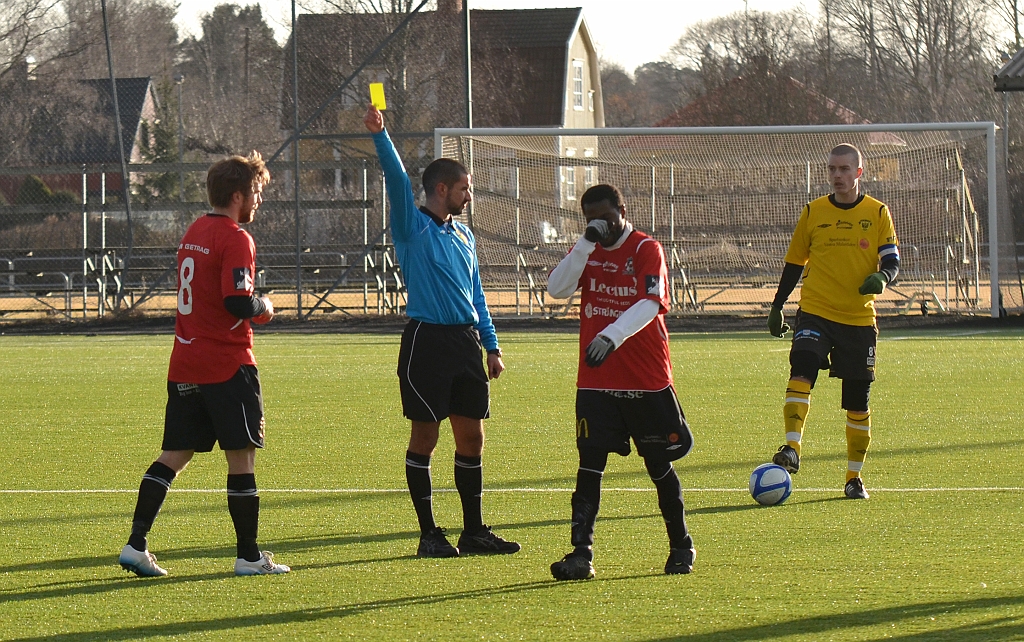 2012_0310_29.JPG - Domaren delar ut ett gult kort till kungsörsspelaren