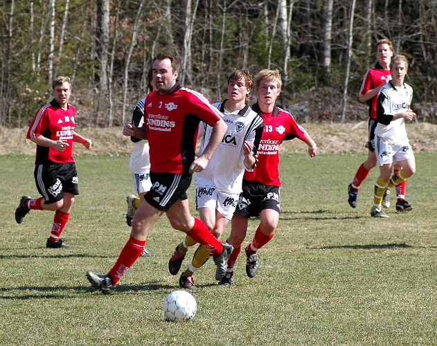 2005_0423_13.jpg - Södras Sebbe Fahlberg inträngd mellan två värhultaspelare men lyckas ända spela upp bollen mot en mötande södraspelare.