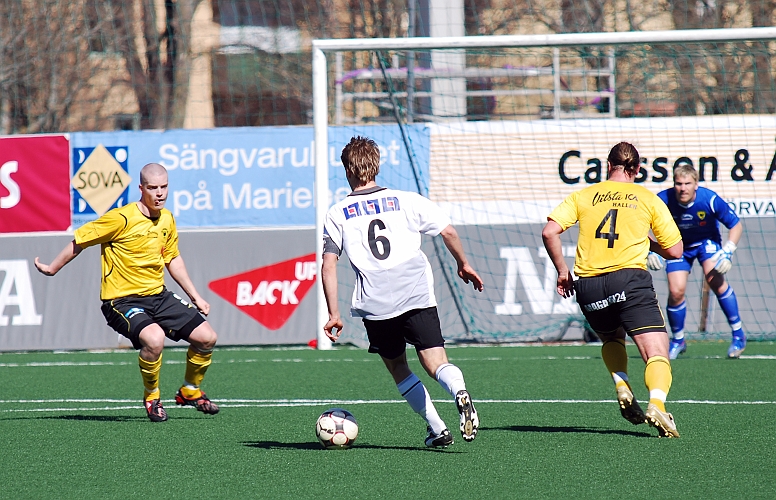 2009_0418_38.JPG - En ÖSK spelare utmanar Södras försvarare Gustav Gustavsson