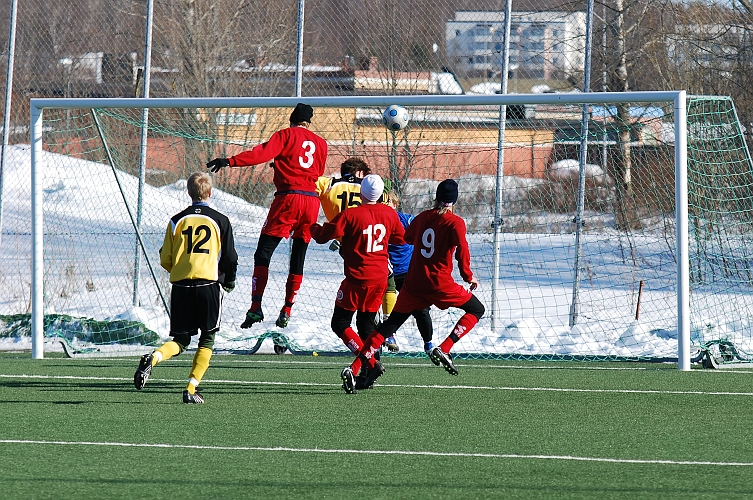 2010_0314_07.JPG - Munktorpsspelaren är högt uppe och försöker nicka in bollen i mål