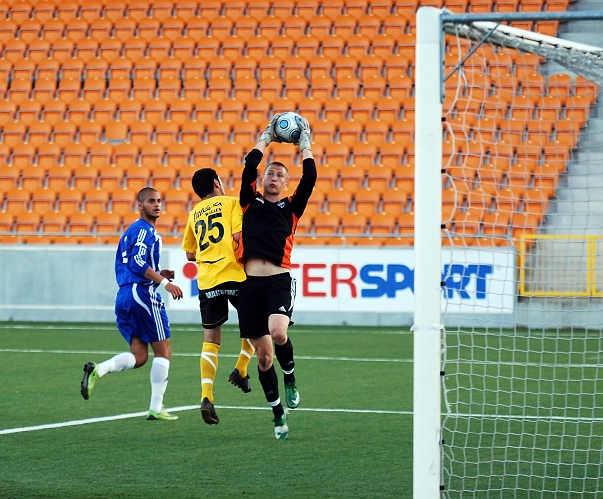 2010_0623_40.JPG - Målvakten plockar ner en höjdboll, uppvaktad av Mergim Bekaj